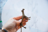 The hand-cast texture and form of the vintage African bronze cheetah's underside.