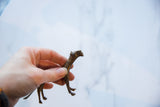 Vintage African bronze cheetah held in hand, showing its collectible size and texture.
