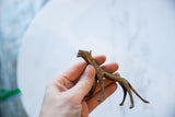 Holding the slender vintage African bronze cheetah to show its scale and handmade texture.