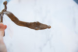 Detailed view of carved patterns and patina on a vintage African bronze snake cuff.