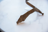Close-up of the incised patterns and aged patina on the vintage bronze snake head cuff.