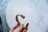 Profile view of the antique African bronze cuff, highlighting its open shape and golden patina.