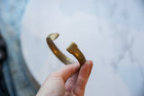 The flared terminals and warm golden patina of the antique bronze snake cuff.