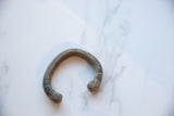 Heavy, antique African snake cuff bracelet showing its curved form and textured copper alloy surface.