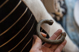 Antique copper snake cuff bracelet held to display its handmade shape and dark, aged patina.