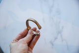 Hand holding the antique snake cuff bracelet to show its scale and aged patina.