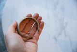 Antique African copper alloy cuff held in hand to show its small scale and patina.