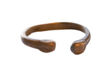 Antique African copper alloy snake cuff bracelet with a smooth, imperfect handmade form.