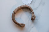 Antique African snake cuff bracelet showing its hand-etched patterns and aged copper patina.