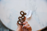 A person holding the vintage African metal snake to show its size and textured patina.