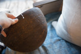 Hand holding the dark wood African bowl, highlighting its carved geometric patterns and rich patina.