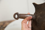 Aged, dark brown wooden handle with a carved ring on the vintage African pitcher.