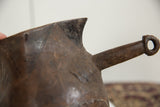 Aged wood handle with textured details on the vintage African pitcher.