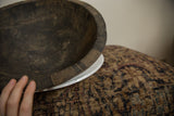 Aged texture and hand-carved linear details on a vintage African wooden bowl.
