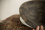 Hand-carved line details on the rustic, dark wood rim of a vintage bowl.