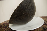 The hand-carved texture and aged character on the side of a black wooden bowl.