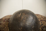 A prominent crack and weathered texture on the surface of the vintage wooden bowl.