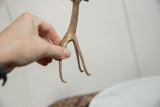 Vintage copper alloy giraffe held to show its handmade scale and textured patina.