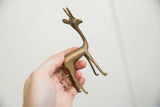 Vintage African bronze fawn's side profile, displaying aged patina and handmade texture.
