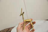 Vintage African bronze gazelle held to show its slender profile and handmade texture.