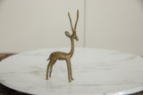 Side view of a vintage African gazelle showing its slender form and oxidized patina.