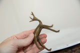 Detail of vintage African gazelle sculpture held in hand, showing aged bronze patina.