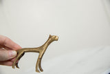 A hand holds the vintage bronze cheetah, showing its slender form and scale.
