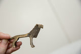 A vintage African bronze lion held in hand, displaying its side profile and scale.