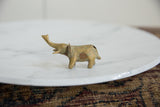 Vintage African bronze elephant sculpture shown in profile with an aged golden patina.