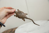 Vintage bronze lizard held to display its handmade, rustic texture and scale.