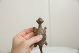 Vintage bronze lizard held in hand to demonstrate its scale and aged, textured patina.