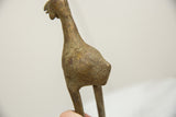 Textured surface of vintage African bronze bird showing etched spiritual patterns, green patina.