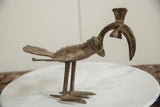 Profile view of the vintage African bronze bird, showing its long curved beak.