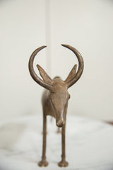 Frontal detail of the vintage African bronze wildebeest's face and curved horns.