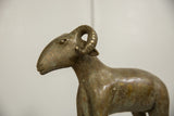 Detailed profile of the vintage African bronze ram's head, highlighting its curled horn.