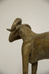 Profile detail of the vintage bronze ram's head, highlighting its ridged horns and textured finish.