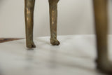 Detailed view of the vintage bronze ram's cast hooves and aged patina.