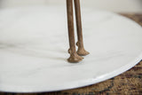 The slender legs and rustic, hand-cast feet of a vintage bronze ram.