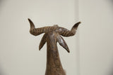 Rear view of the vintage African bronze ram, showing its textured, ridged horns.