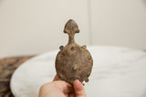Vintage African bronze turtle held in hand, displaying textured shell with concentric circles.