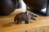 Side view of the vintage bronze hippo showing its stout body and rough, handmade texture.