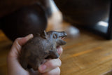 Vintage African bronze hippo held in hand to show its scale and textured patina.