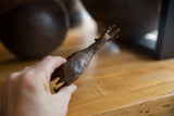 Hand holding vintage African bronze antelope, revealing textured bronze and golden horns.