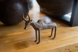Side profile of a handmade African bronze zebu showing its aged, rustic patina.