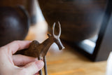 A vintage African bronze zebu held in hand, detailing its rustic, handmade texture.