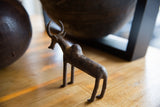 The slender profile and textured surface of a handmade vintage bronze zebu figurine.