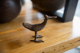 Side view of a vintage African bronze flat billed bird with textured, dark patina.