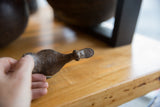 Detailed view of the vintage African bronze flat billed bird's textured head.