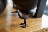 Vintage African bronze flat-billed bird sculpture showing its handmade texture in a profile view.