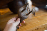 Hand holding the vintage African bronze Kori Bustard, revealing its aged texture and leg.